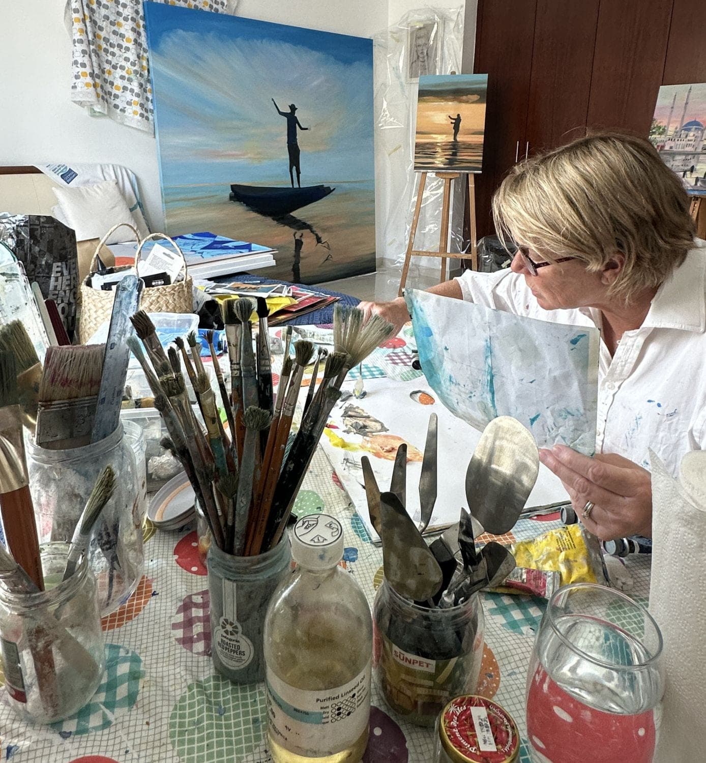 Nathalie Wright at her studio table, among brushes and palette knives